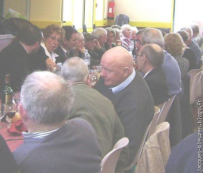 la Présidente Josette sert à boire à M. le Curé.Jean Saouter écoute...